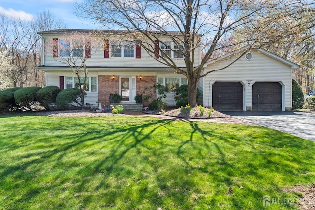 view of front facade with an attached garage, asphalt driveway, a front lawn, and brick siding