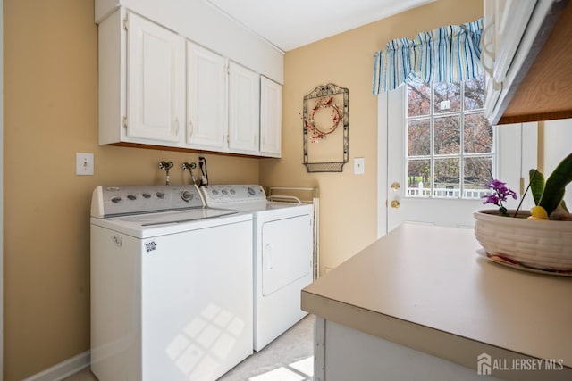 clothes washing area featuring cabinet space and washer and dryer