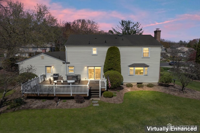 back of property at dusk with a chimney, a lawn, and a wooden deck