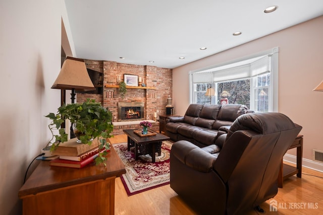 living area with light wood finished floors, a fireplace, and recessed lighting