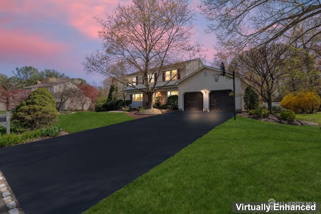 traditional home featuring a garage, asphalt driveway, and a front lawn