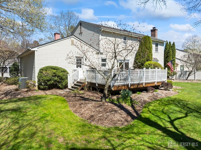 back of house with a chimney, cooling unit, and a wooden deck