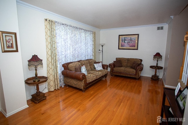 living room with hardwood / wood-style flooring and crown molding