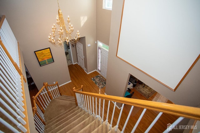 stairway with an inviting chandelier and a high ceiling