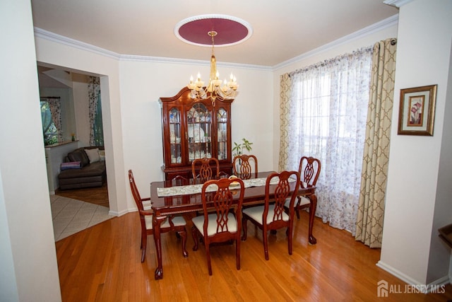 dining room featuring wood-type flooring, a chandelier, and crown molding