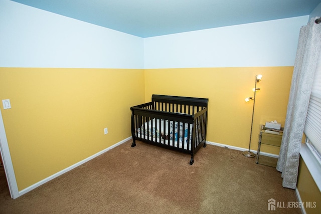 bedroom featuring a nursery area and carpet floors