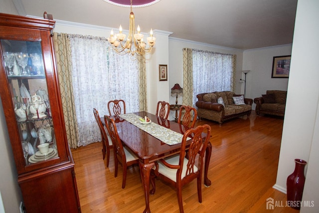 dining room with wood-type flooring, a chandelier, and ornamental molding