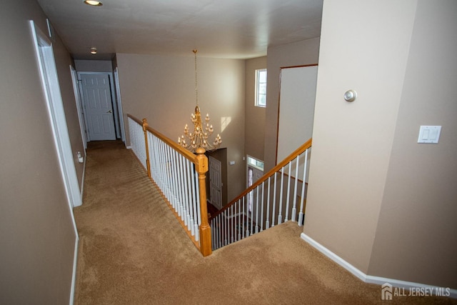 corridor featuring carpet flooring and an inviting chandelier