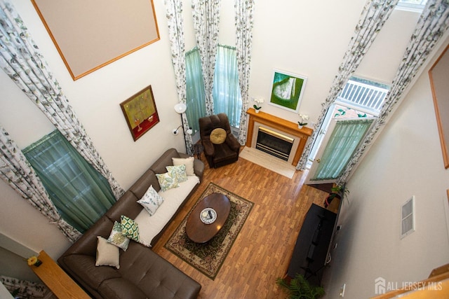 living room with hardwood / wood-style flooring and a towering ceiling