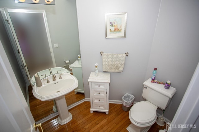 bathroom with toilet and hardwood / wood-style floors