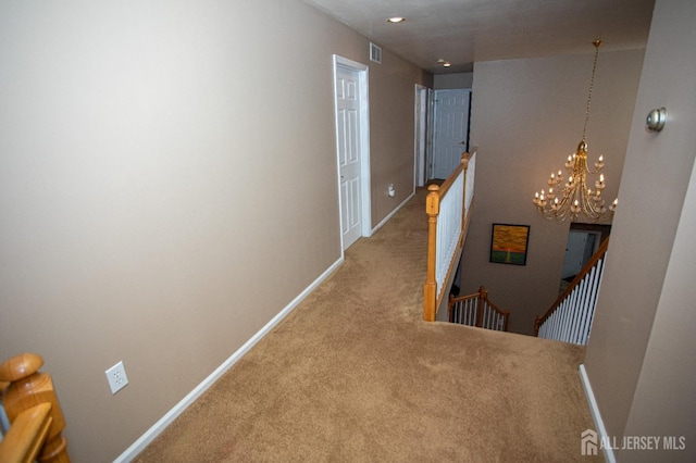 hallway with a notable chandelier and carpet floors