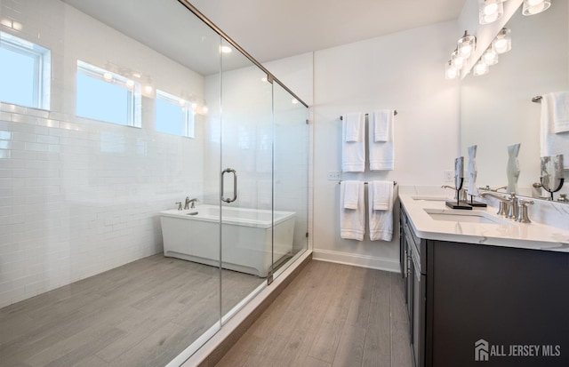 302 Nash Ave, West Windsor, NJ 08550 - full bathroom with a sink, double vanity, a freestanding tub, a shower stall, and wood finished floors