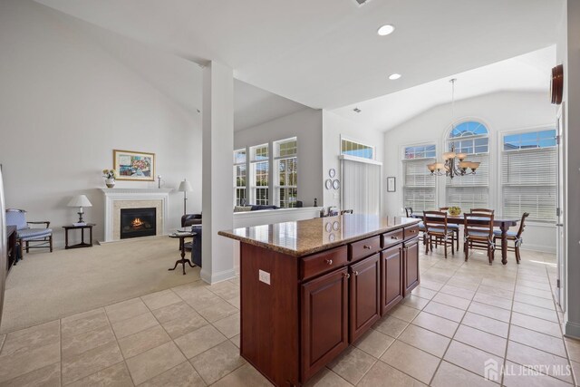 1 Jester Ct, Monroe, NJ 08831 - kitchen featuring lofted ceiling, a lit fireplace, light stone counters, baseboards, and light carpet