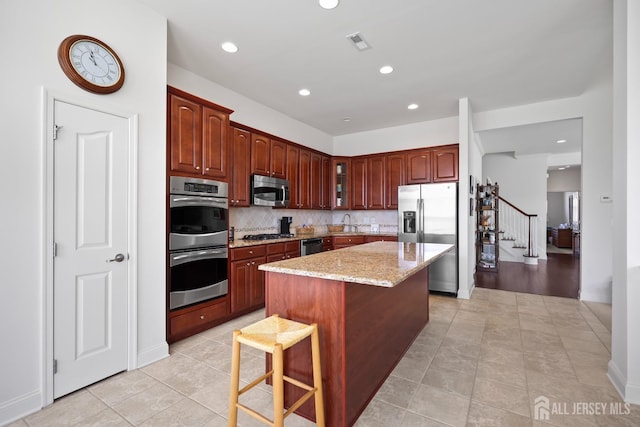 1 Jester Ct, Monroe, NJ 08831 - kitchen featuring stainless steel appliances, glass insert cabinets, light stone countertops, decorative backsplash, and a center island