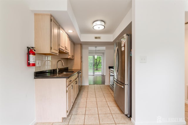 44 Treat Ln, East Brunswick, NJ 08816 - kitchen with stainless steel appliances, light brown cabinetry, decorative backsplash, light tile patterned flooring, and a tray ceiling