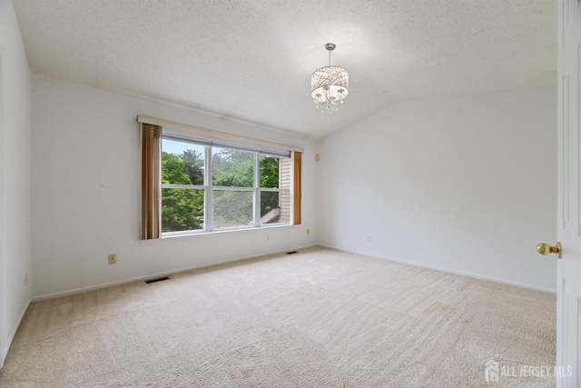 44 Treat Ln, East Brunswick, NJ 08816 - empty room with carpet floors, a chandelier, vaulted ceiling, and a textured ceiling