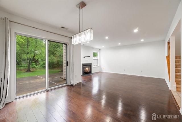 44 Treat Ln, East Brunswick, NJ 08816 - unfurnished living room with hardwood / wood-style flooring, recessed lighting, a glass covered fireplace, and a chandelier