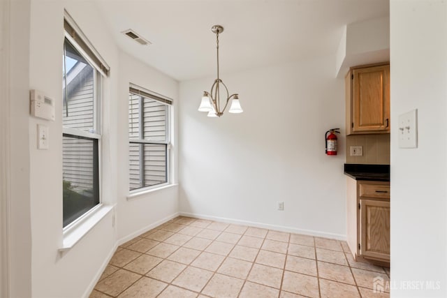 44 Treat Ln, East Brunswick, NJ 08816 - unfurnished dining area featuring a chandelier and light tile patterned floors