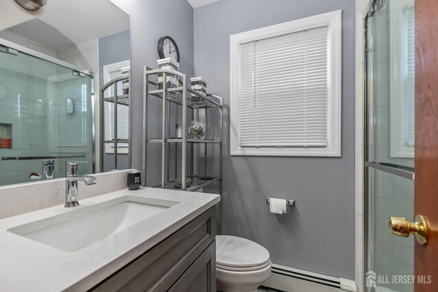 bathroom featuring vanity, a baseboard heating unit, toilet, and walk in shower