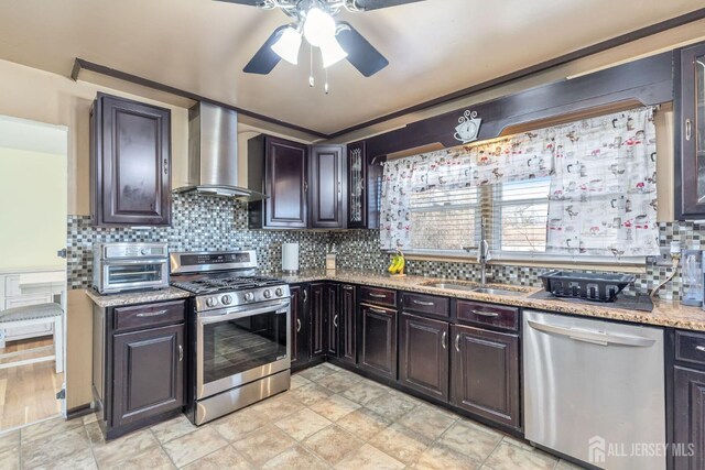 kitchen with wall chimney exhaust hood, sink, dark brown cabinets, stainless steel appliances, and decorative backsplash