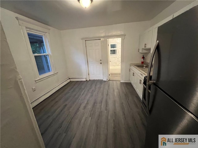 425 John St, Plainfield, NJ 07060 - kitchen with freestanding refrigerator, white cabinetry, dark wood-style floors, light countertops, and baseboard heating
