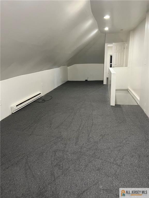 425 John St, Plainfield, NJ 07060 - bonus room featuring a baseboard radiator, vaulted ceiling, and dark colored carpet