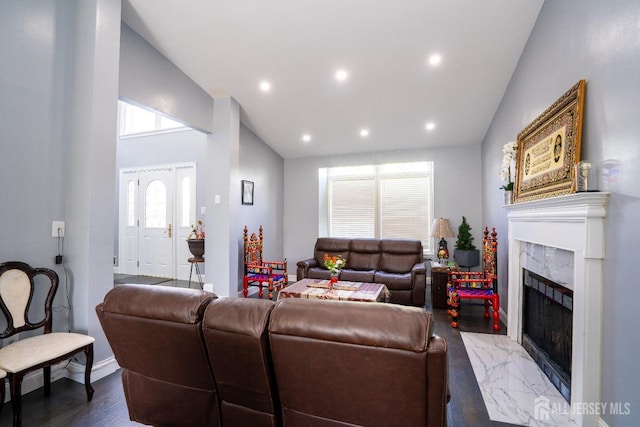 living area with vaulted ceiling, recessed lighting, marble finish floor, and a high end fireplace