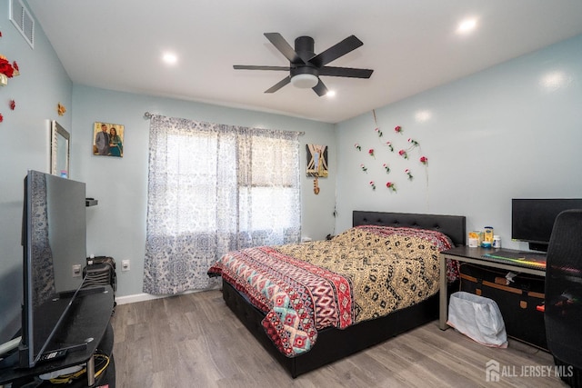 bedroom with visible vents, a ceiling fan, and wood finished floors