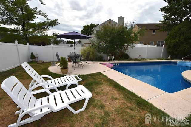 view of pool with a fenced in pool, a patio, a lawn, and a fenced backyard