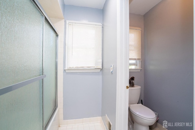 full bathroom featuring visible vents, toilet, baseboards, and bath / shower combo with glass door