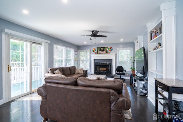 living area featuring recessed lighting, a fireplace, dark wood-type flooring, and ceiling fan