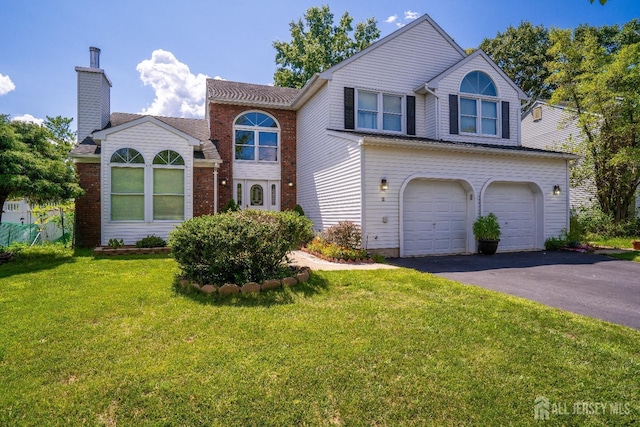 traditional home featuring aphalt driveway, a front yard, and an attached garage