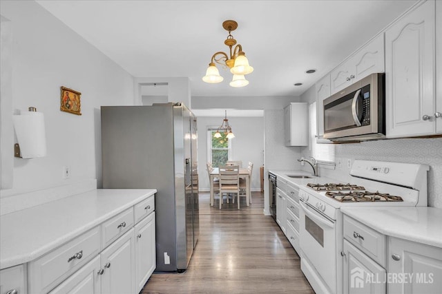218 Winthrop Ave, Moorestown, NJ 08057 - kitchen featuring stainless steel appliances, a chandelier, white cabinets, wood finished floors, and a sink