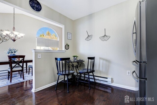 dining space with a baseboard heating unit, an inviting chandelier, and dark hardwood / wood-style floors