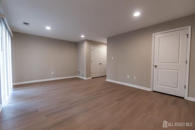 below grade area with baseboards, recessed lighting, wood finished floors, and visible vents