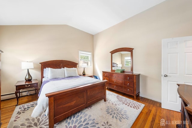 bedroom with vaulted ceiling, a baseboard radiator, wood finished floors, and baseboards