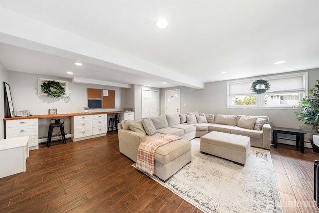 living room featuring a baseboard heating unit, built in desk, and dark wood-type flooring