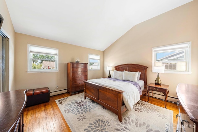 bedroom with light wood finished floors, a baseboard radiator, and vaulted ceiling