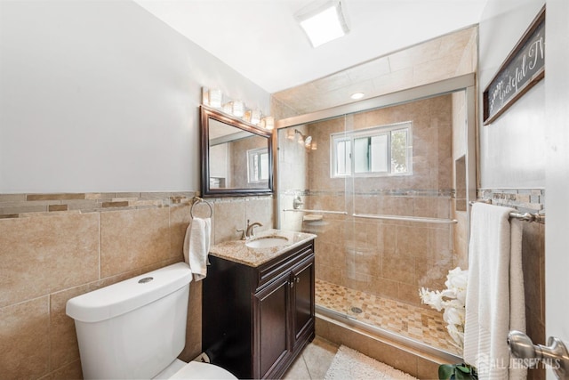 bathroom featuring tile walls, vanity, walk in shower, toilet, and tile patterned floors