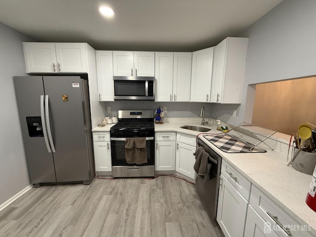 104 Morgan Pl E, Brunswick, NJ 08816 - kitchen with appliances with stainless steel finishes, a sink, light wood finished floors, and white cabinets