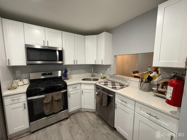 104 Morgan Pl E, Brunswick, NJ 08816 - kitchen with appliances with stainless steel finishes, light wood-style flooring, and white cabinets