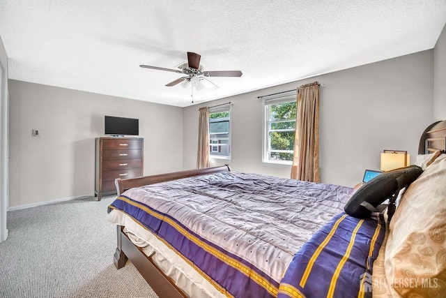 bedroom featuring carpet floors, a textured ceiling, ceiling fan, and baseboards
