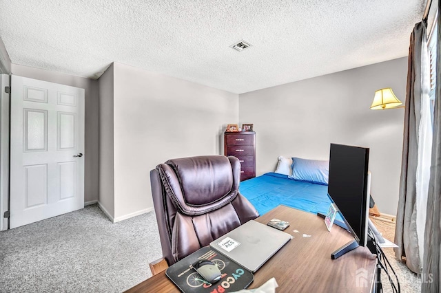 carpeted home office with baseboards, a textured ceiling, and visible vents