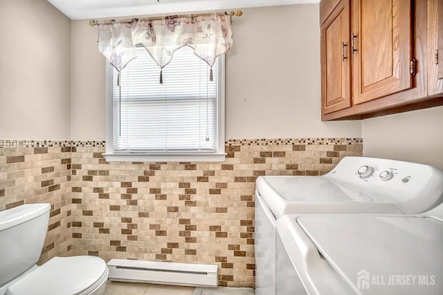 laundry room featuring laundry area, separate washer and dryer, plenty of natural light, tile walls, and a baseboard radiator
