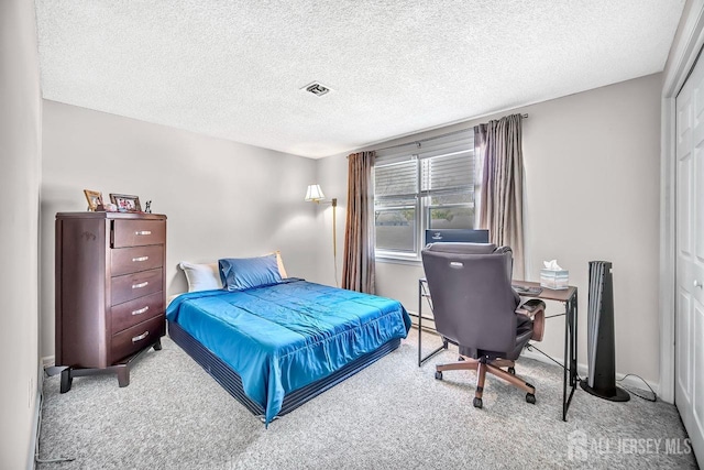 carpeted bedroom with a textured ceiling, visible vents, and a closet