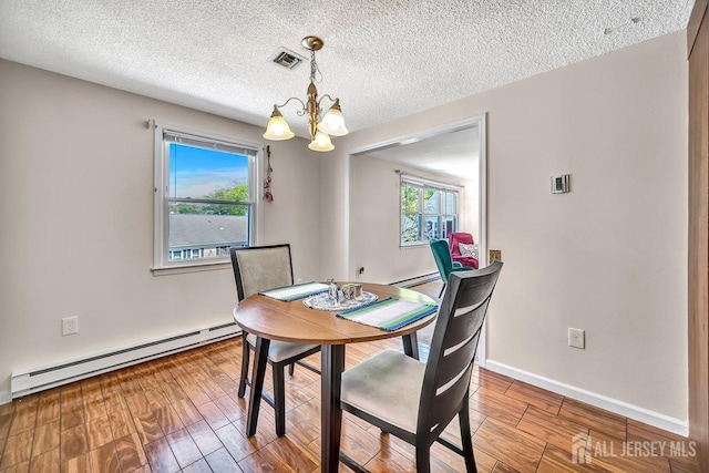 dining area with a chandelier, visible vents, wood finished floors, and a baseboard radiator