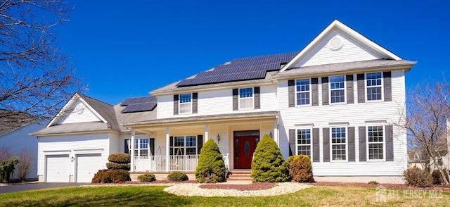 4 Cottonwood Ct, Plainsboro, NJ 08536 - traditional-style house with covered porch, solar panels, a garage, driveway, and a front lawn