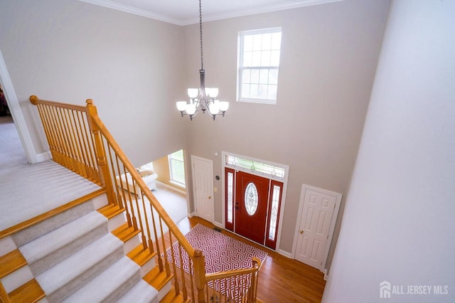 4 Cottonwood Ct, Plainsboro, NJ 08536 - foyer entrance featuring a chandelier, baseboards, ornamental molding, wood finished floors, and stairs