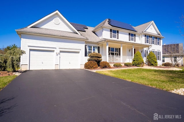 4 Cottonwood Ct, Plainsboro, NJ 08536 - view of front of home featuring a porch, asphalt driveway, a front yard, and roof mounted solar panels