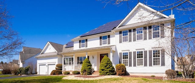 4 Cottonwood Ct, Plainsboro, NJ 08536 - traditional-style house featuring covered porch, solar panels, a garage, a front yard, and driveway